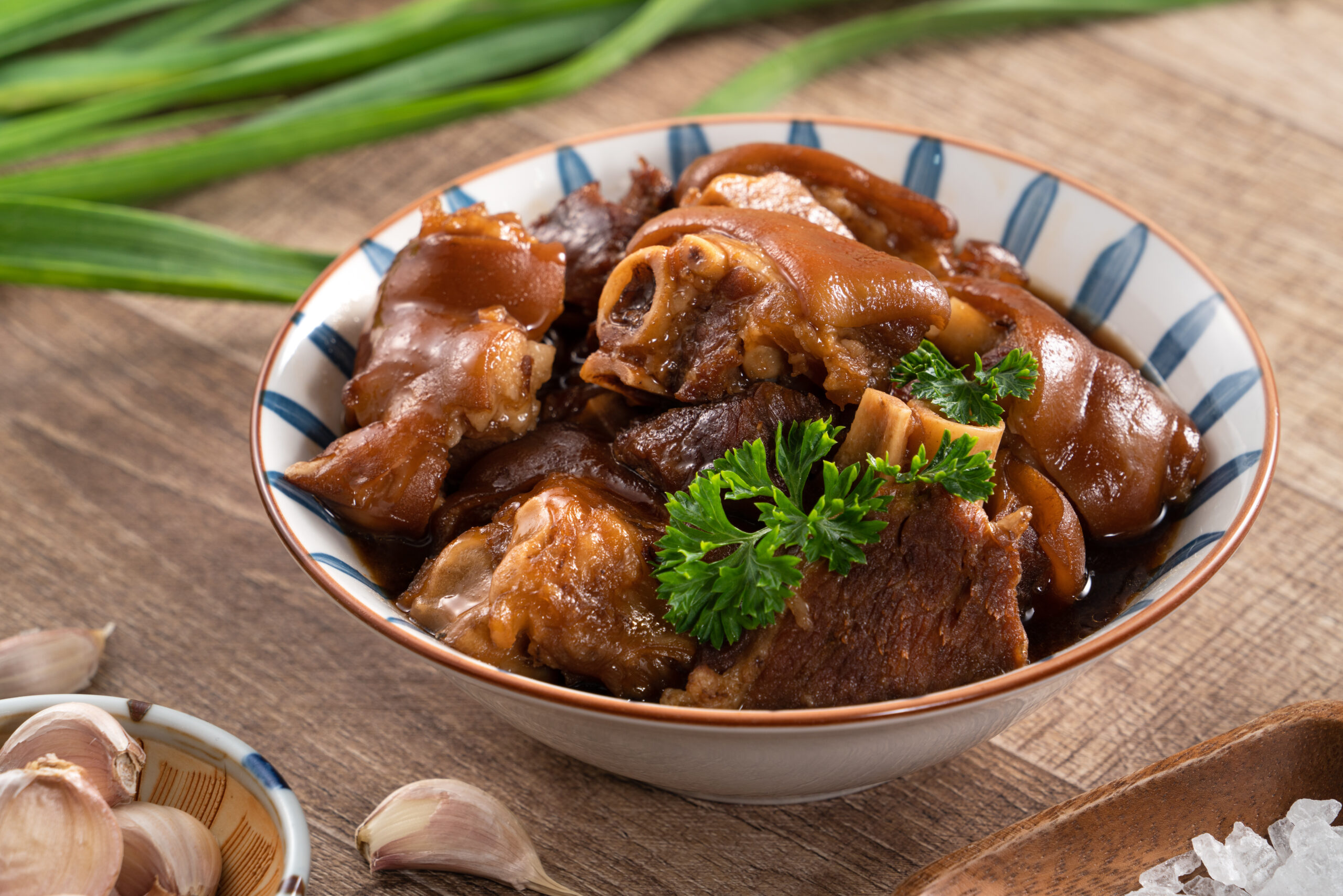 Taiwanese traditional food pork knuckle in a bowl Close up of Taiwanese traditional food pork knuckle in a bowl on rustic table background.